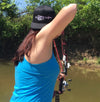 woman bow fishing at full draw on the river with shooting fish hat