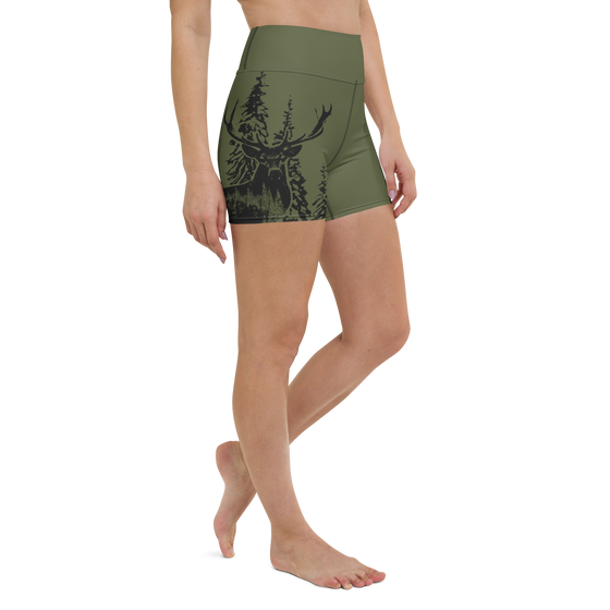 Up close of a woman wearing woodland logo shorts from river to ridge brand in olive OD green that are fitted like yoga shorts and have a high / wide waistband and an elk on the hip