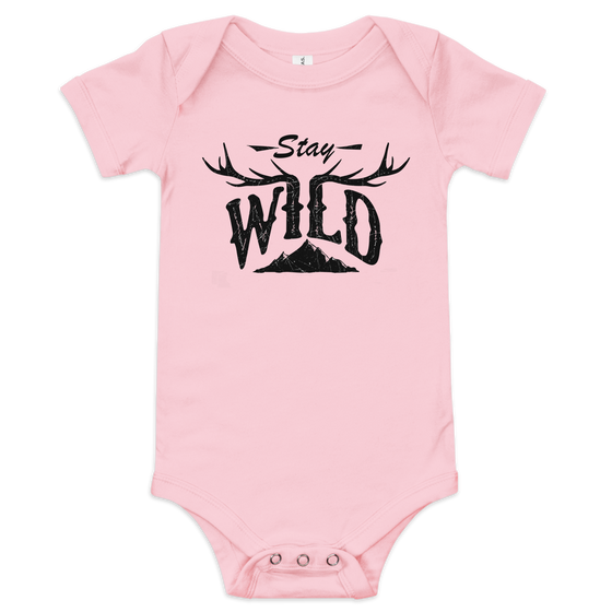 Stay Wild Logo on a baby one piece in pink and the logo has elk antlers on it and a mountain, onesie