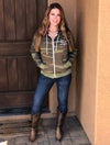 red head woman in cowboy boots and jeans wearing a camo zip up hoodie with arrows on it