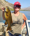 Woman at lake holding up a big bass fishing and wearing a River to Ridge olive muscle tank top with an elk on it