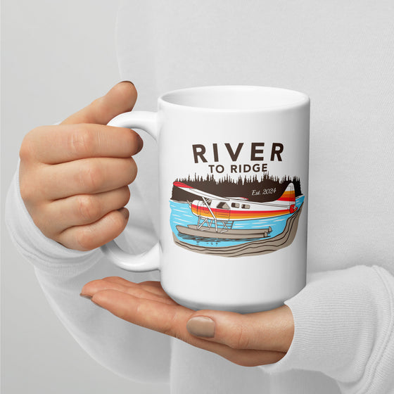 River to Ridge Brand Coffee Mug with a bush plane Alaskan logo on it on floats in a lake - backcountry taxi