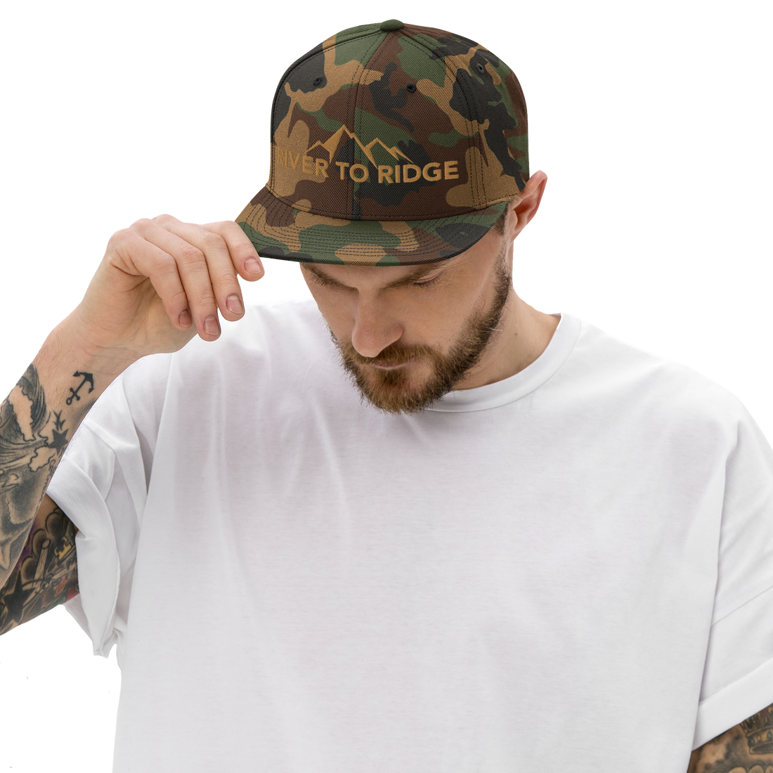  man with arm sleeve tattoos and white t shirt wearing a River to Ridge Logo Brand Camo Snapback hat with the mountain logo stitched on it