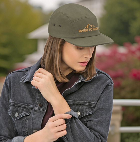 Woman outdoors wearing a jean jacket and wearing a retro vintage classic Camp Hat in Olive from River to Ridge Clothing Brand