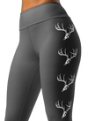 close up photo of a woman wearing grey yoga leggings with a big whitetail buck on them with the euro skull and antlers in grey