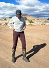 pretty woman standing on dirt road wearing elk sweatshirt, hat and work pants and camo rubber boots