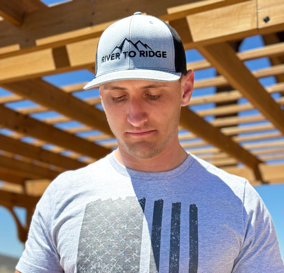 Man wearing a grey and black River to Ridge Logo Hat and a Tactical USA T shirt