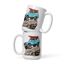  River to Ridge brand coffee mugs stacked on top of each other. Featuring a bronco on top of a rock in vintage blue and the truck has a red kayak on top of it