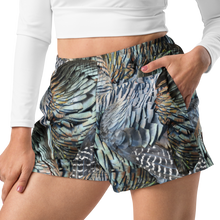  close up of woman wearing relaxed fit athletic shorts with pockets in a turkey feather pattern from river to ridge and a white crop top shirt