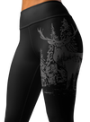 close up of a woman wearing leggings with a wide waistband and a logo of an elk red stag on it in black and grey