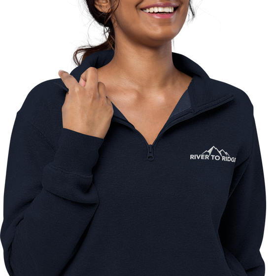 Womens Half zip pullover from River to Ridge clothing brand with the logo on the left chest and sleeve - close up of woman wearing it in navy blue