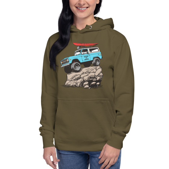 Woman wearing a vintage classic bronco hoodie with a drawing of the truck with a red kayak on top and its up on a big rock, from the brand River to Ridge