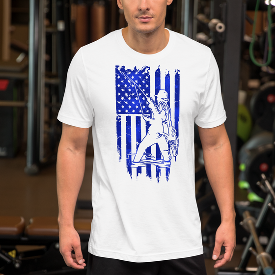 Men's Patriotic Fishing Logo T shirt in white with blue graphics, drawing of a man fly fishing in a river over a USA flag. From River to Ridge Brand. Man wearing the T shirt at the gym