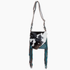 A black and white cow-print shoulder bag with turquoise fringe and silver hardware, River to ridge