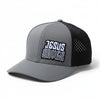Black and gray baseball cap with 'Jesus Saves' text on a stone surface