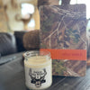 Candle with 'Follow the Word' label and camouflage-patterned Bible on a surface