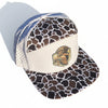 Cap with duck camo print visor and logo on a gravel surface