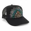 A black trucker hat with a curved brim, black mesh back, and a detailed front panel graphic featuring a peacock feather pattern in teal, brown, and white.
