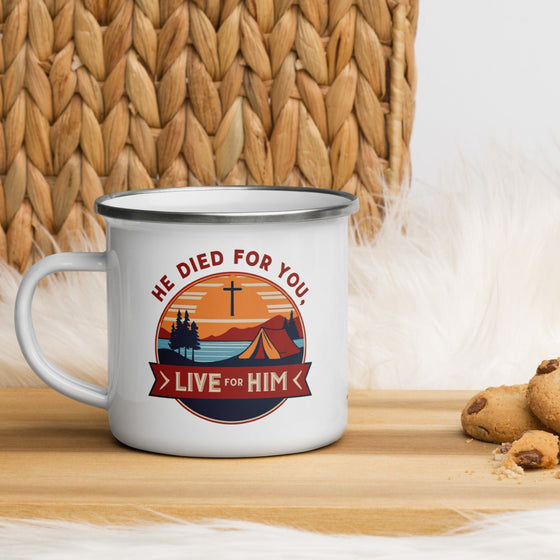 Product mockup of a Christian enamel camping mug from River to Ridge clothing brand featuring the saying "he died for you, live for him" and a camping scene in red and orange and blue
