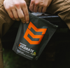 Person holding a 'MTN OPS Hydrate' package with an orange logo.