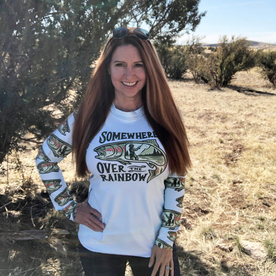 Person wearing a white sweatshirt with text and graphics outdoors