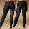 Black leggings with nature-themed design on a wooden background