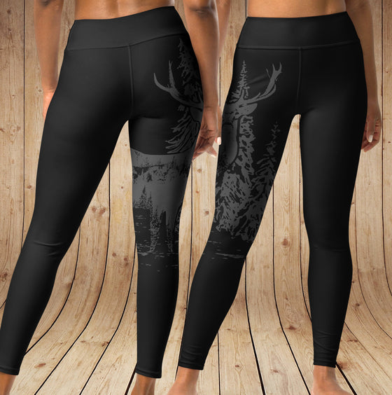 Black leggings with nature-themed design on a wooden background