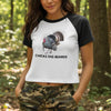 Woman wearing a t-shirt with a graphic and text in a forest setting