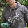 Person wearing a gray hoodie with a elk design outdoors