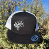 Black and white cap with a elk antler design on a natural background