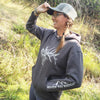 Person wearing a 'River to Ridge' hoodie in a natural setting