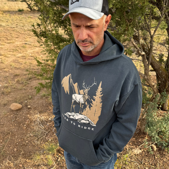 Man wearing a hoodie with a nature-themed design outdoors