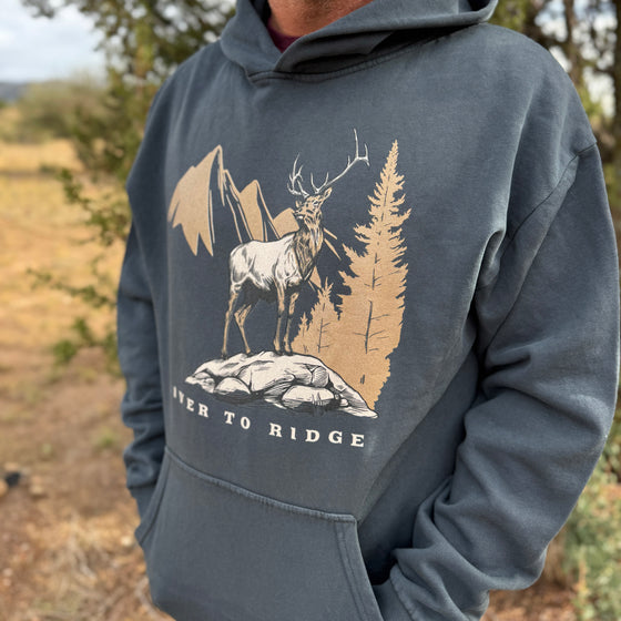 Person wearing a hoodie with a nature-themed graphic and text 'Never to Ridge'.