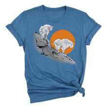  Blue t-shirt with a graphic of two mountain goats on a rock and an orange sun in the background