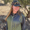 Woman wearing a camouflage cap and outdoor jacket in a natural setting