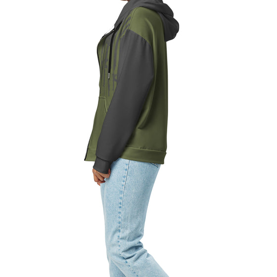 Person wearing a green and black hoodie with light blue jeans on a white background