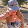 Woman wearing a 'River to Ridge' cap outdoors