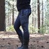 Person wearing dark leggings with a forest design in a wooded area