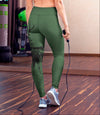 Person wearing green leggings holding a jump rope in a gym setting