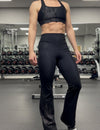 Person wearing black athletic pants and top in a gym setting