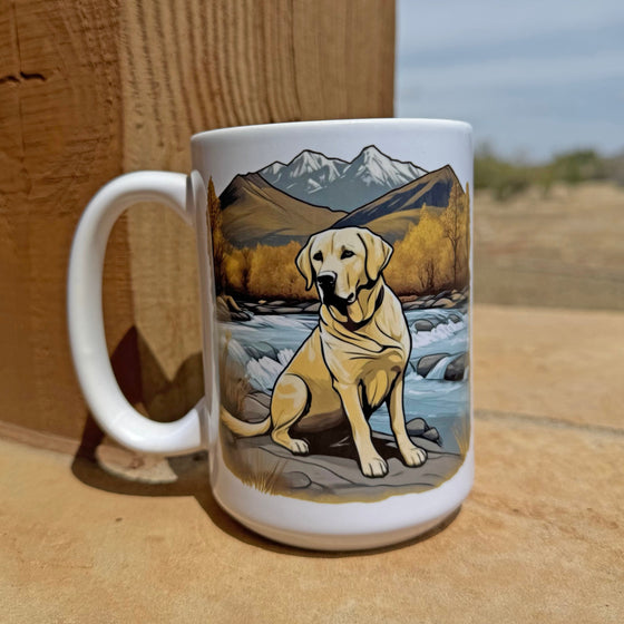 Product mockup of a River to Ridge Clothing Brand Yellow Lab Coffee Mug with a dog sitting by a river and mountains in the background
