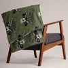 Green blanket with skull and crossbones design draped over a wooden chair.