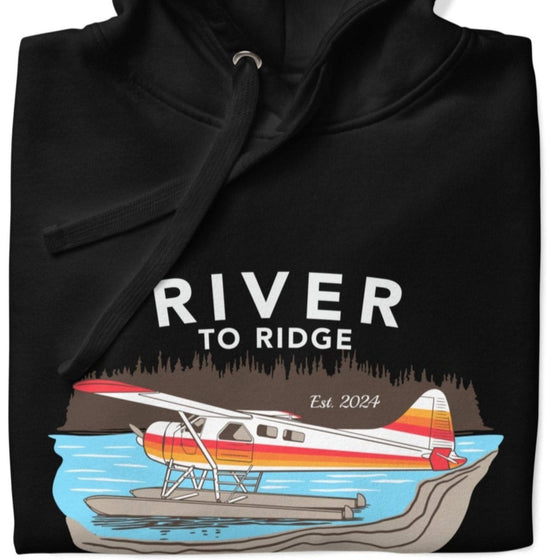 Men's Backcountry Taxi Hoodie from River to Ridge Clothing Brand with an Alaskan Bush Plane, Otter on floats on a lake on a black pullover