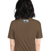 Person wearing a brown t-shirt with a small graphic on the back, standing against a white background