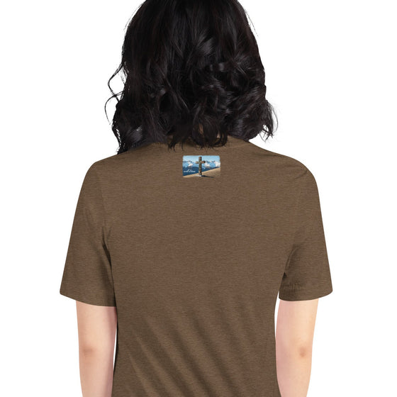 Person wearing a brown t-shirt with a small graphic on the back, standing against a white background