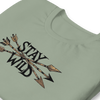 Product mockup of a River to Ridge Clothing Brand T Shirt for Women with the Stay Wild Archery Bowhunting Logo on it with traditional african arrows