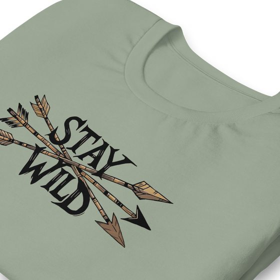 Product mockup of a River to Ridge Clothing Brand T Shirt for Women with the Stay Wild Archery Bowhunting Logo on it with traditional african arrows