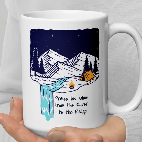 Product mockup of a Christian Outdoor Lifestyle Coffee Mug from River to Ridge Clothing Brand with a mountain scene and tent and uplifting words.